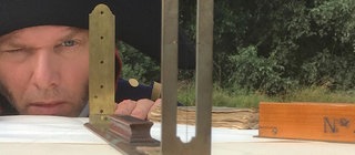 Nachgestellte Szene: Tulla benutzt ein Instrument um eine gerade Linie festzulegen.