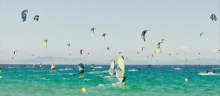Surfer und Kitesurfer auf dem Meer