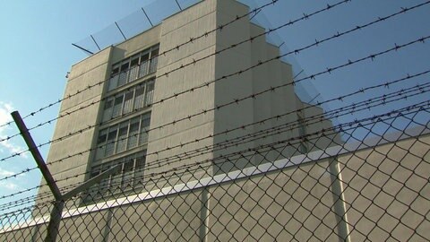 Gebäude der JVA Stuttgart-Stammheim hinter Mauer u. Stacheldraht