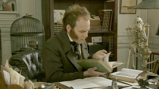 Spielszene: Darwin arbeitet am Schreibtisch