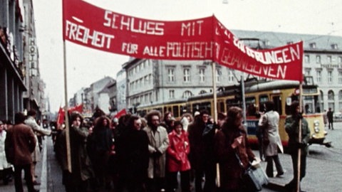 Demonstrationszug mit rotem Transparent