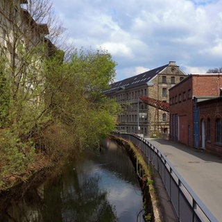 Die Wupper eingezwängt zwischen einer Straße und Gebäuden
