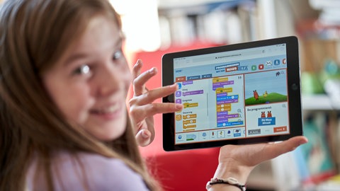 Ein Kind nutzt auf einem Tablet das Spiel 