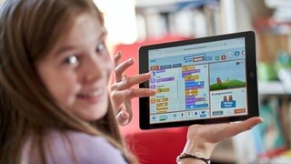 Ein Kind nutzt auf einem Tablet das Spiel "Programmieren mit der Maus"