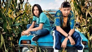 Zwei Teenager auf einem Auto im Maisfeld