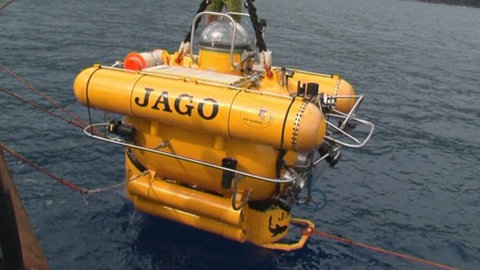 Ein gelbes Tiefseetauchboot mit der Aufschrift "Jago" wird vom Forschungsschiff zu Wasser gelassen