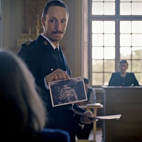 Joseph Granier in Uniform hält ein Foto hoch.