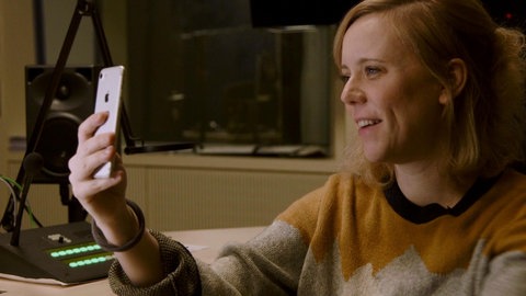 Christina Wolf schaut auf ihr Smartphone.
