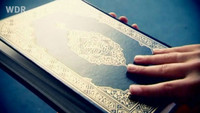 Koran mit darauf liegender Hand