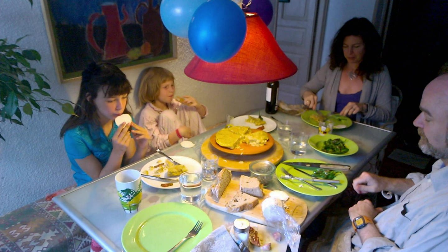 Eine Familie am Tisch beim Abendessen.