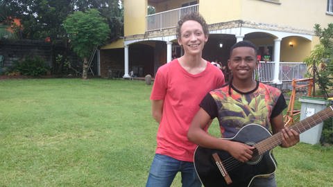 Zwei junge Männer stehen vor einem Haus. Einer hält eine Gitarre. (Foto: WDR - Screenshot aus der Sendung)
