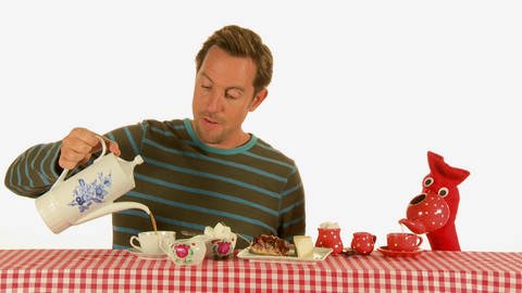Ein Mann und eine rote Strumpfhandpuppe trinken gemeinsam Tee und essen Kuchen. (Foto: WDR - Screenshot aus der Sendung)