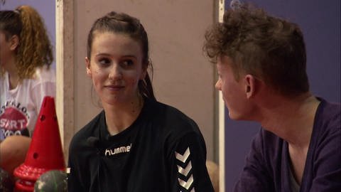 Der männliche Moderator spricht mit einer jungen Handballspielerin. (Foto: WDR - Screenshot aus der Sendung)