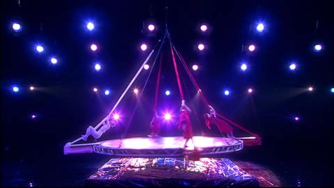 Vier Artisten klettern an Seilen einer sich drehende Scheibe empor. (Foto: SWR - Screenshot aus der Sendung)
