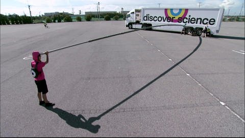 Eine Person hält einen sehr langen Hebel, der unter einen Lastwagen geklemmt ist. (Foto: SWR - Screenshot aus der Sendung)