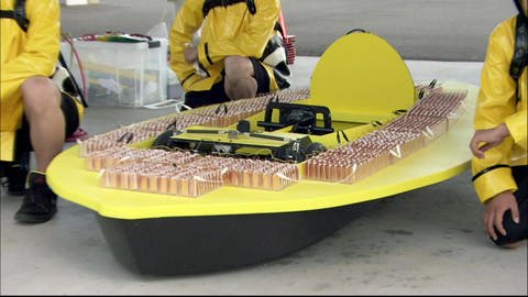 Ein gelbes, selbstgebautes Auto ist versehen mit vielen Batterien. (Foto: SWR - Screenshot aus der Sendung)