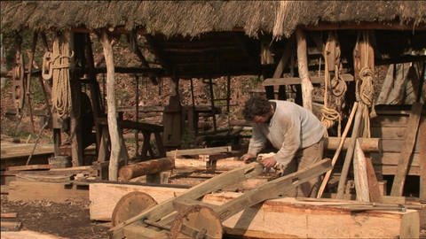 Ein Mann bearbeitet einen kleinen Wagen aus Holz mit einem Ziehmesser.  (Foto: WDR / SWR - Screenshot aus der Sendung)
