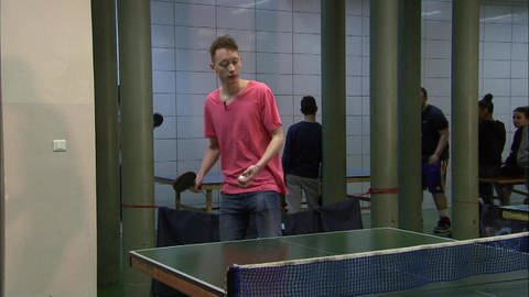 Ein junger Mann steht in einer Turnhalle und spielt Tischtennis. (Foto: WDR - Screenshot aus der Sendung)