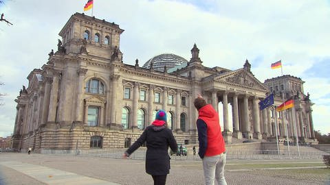 Ein Mann und eine Frau stehen in Berlin vor dem Reichstag. (Foto: SWR / BR / WDR - Screenshot aus der Sendung)