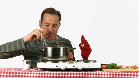 Ein Mann und eine rote Strumpfhandpuppe rühren in einem Topf und kochen Suppe. (Foto: WDR - Screenshot aus der Sendung)