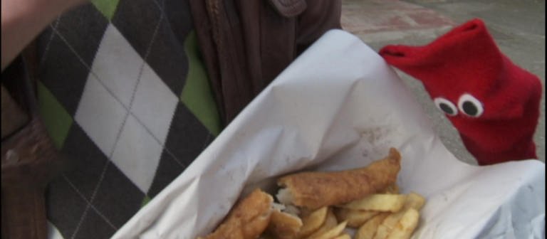 Eine Hand hält eine Portion Fish and Chips. (Foto: WDR - Screenshot aus der Sendung)