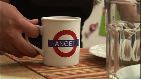 Ein weißer Becher mit dem Schriftzug "Angel" in Form des englischen U-Bahn-Schilds. (Foto: WDR)