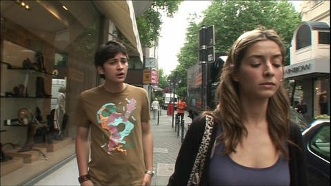 Ein junger Mann und eine junge Frau laufen durch die Stadt und streiten. (Foto: WDR)