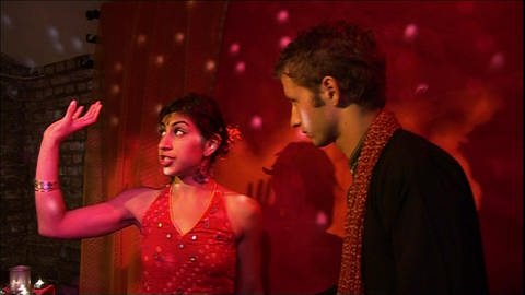Ein junger Mann und eine junge Frau stehen in einem Raum mit rotem Party Licht. (Foto: WDR)