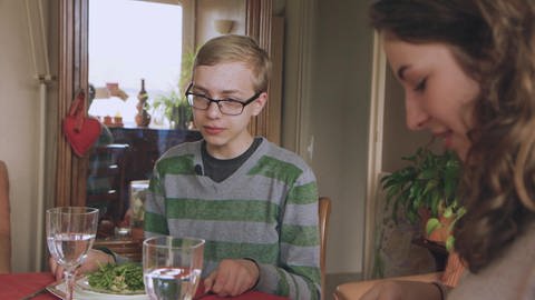 Ein Junge und eine junge Frau sitzen gemeinsam am Tisch und essen. (Foto: WDR)