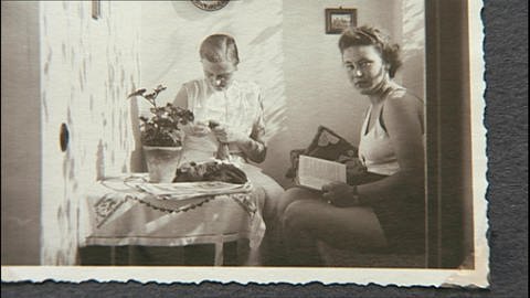 Ein schwarz-weiß Foto von zwei Frauen. Die eine liest, die andere sitzt am Tisch und arbeitet. (Foto: WDR)