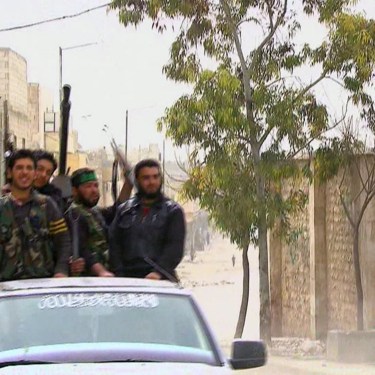 Bewaffnete Kämpfer einer syrischen Miliz auf der Ladefläche eines Pick-Ups. (Foto: SWR)