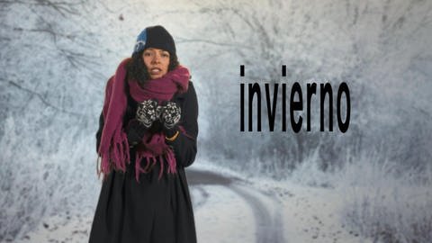 Eine Frau steht auf einer schneebedeckten Straße. Sie trägt dicke Winterkleidung. Neben ihr der Schriftzug "invierno". (Foto: WDR)