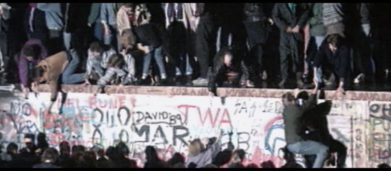 Aufnahme, die viele Menschen auf der Berliner Mauer 1989 zeigt. (Foto: SWR)