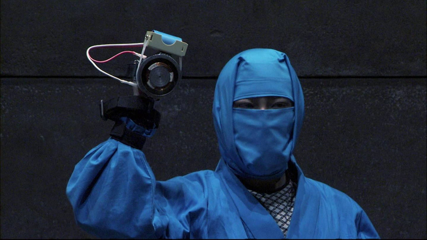 Ein blau gekleideter Ninja hält einen Magneten in der Hand. (Foto: SWR - Screenshot aus der Sendung)