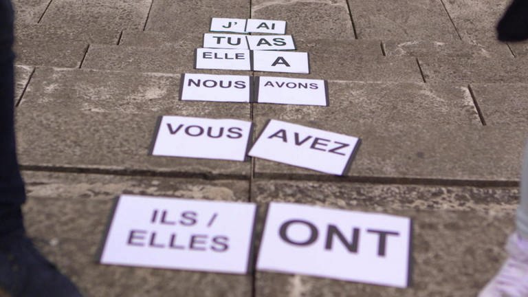 Auf dem Boden liegen Schilder, darauf stehen französische Pronomen und die Konjugationen von "avoir". (Foto: WDR)