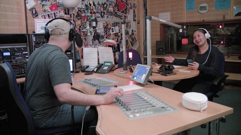 Ein Mädchen und ein Mann sitzen in einem Tonstudio und sprechen in Mikrofone. (Foto: WDR)