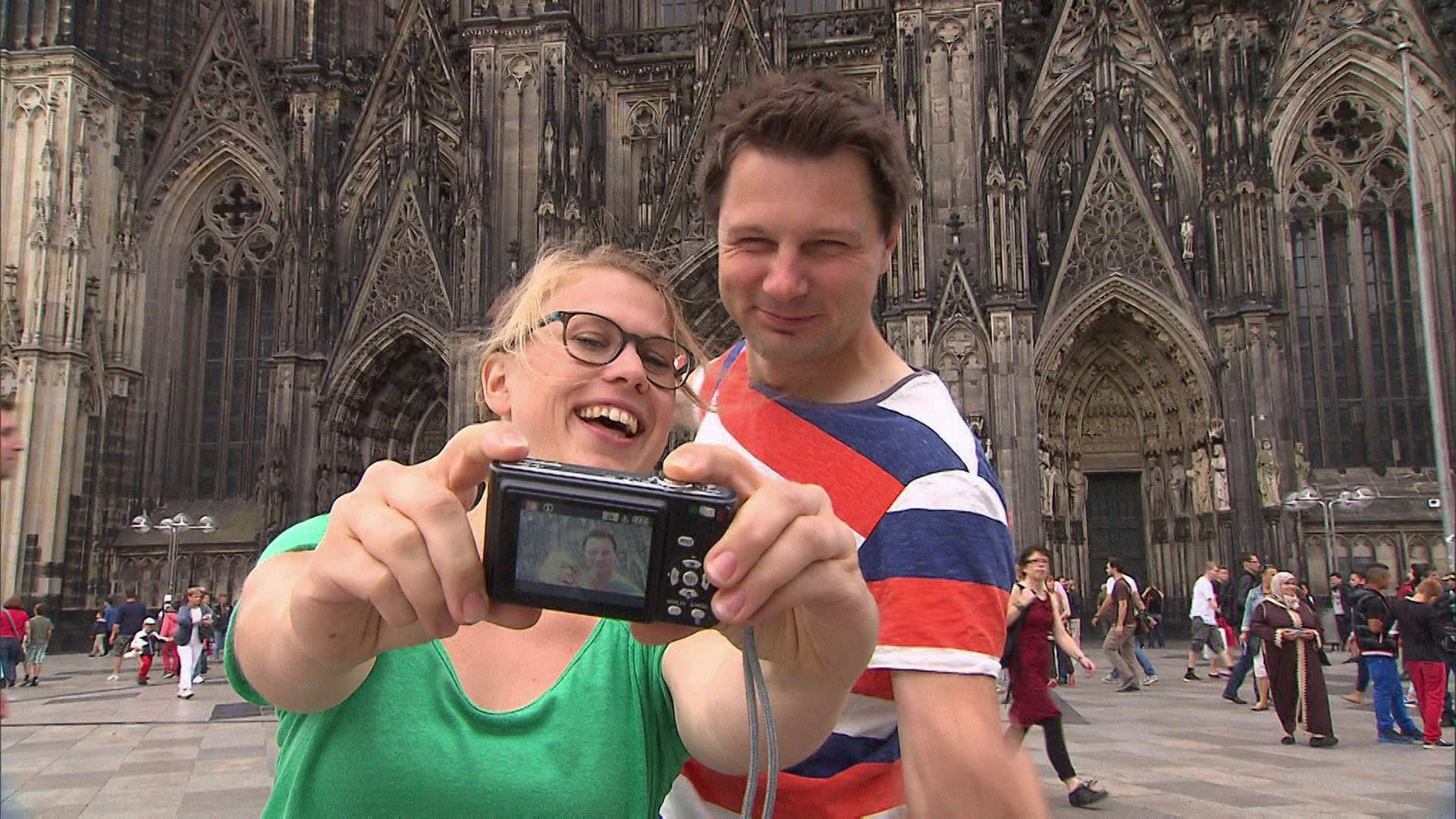 Eine Frau und ein Mann machen ein Selfie vor dem Kölner Dom. (Foto: SWR / BR / WDR - Screenshot aus der Sendung)