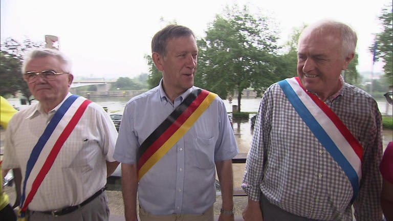 Drei Männer mit verschiedenen Schärpen stehen nebeneinander. (Foto: SWR / BR / WDR - Screenshot aus der Sendung)