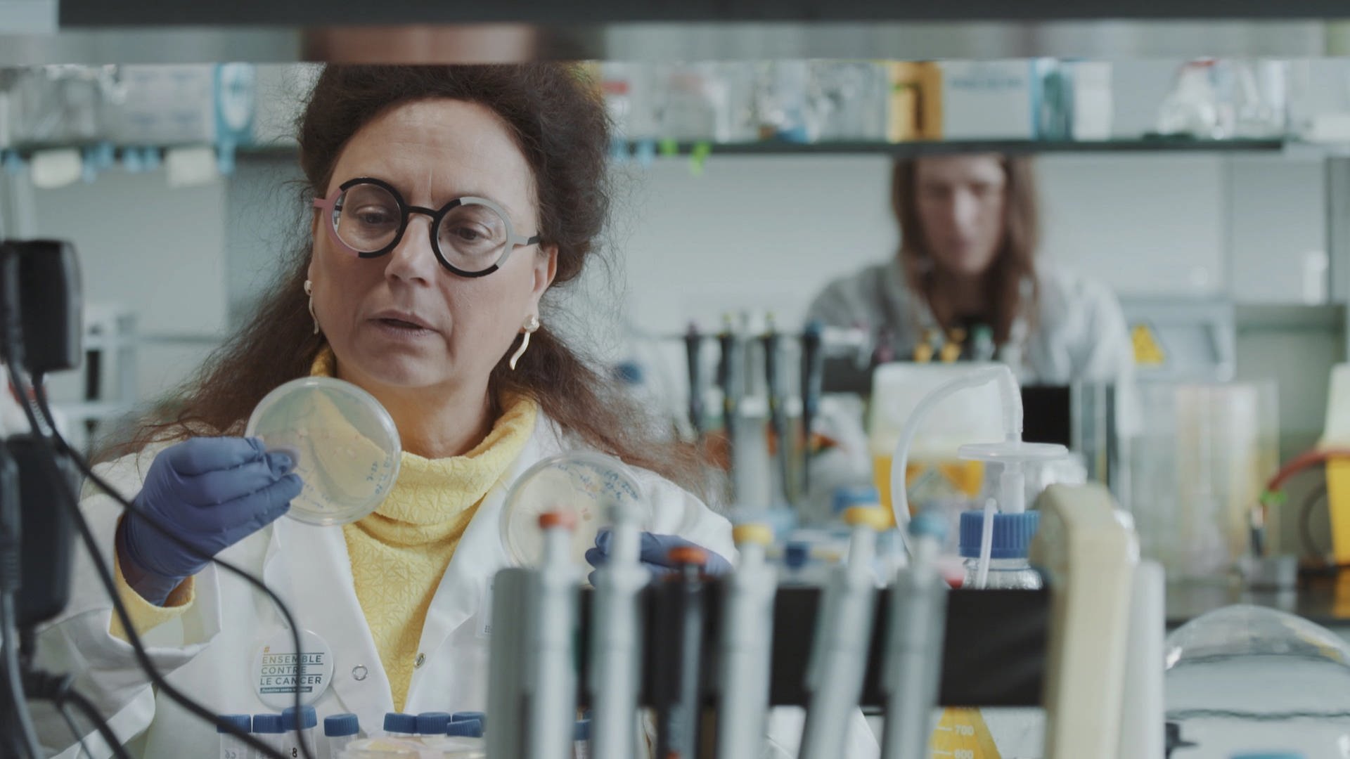 Eine Frau im Laborkittel betrachtet eine Petrischale in ihrer Hand. (Foto: SWR)