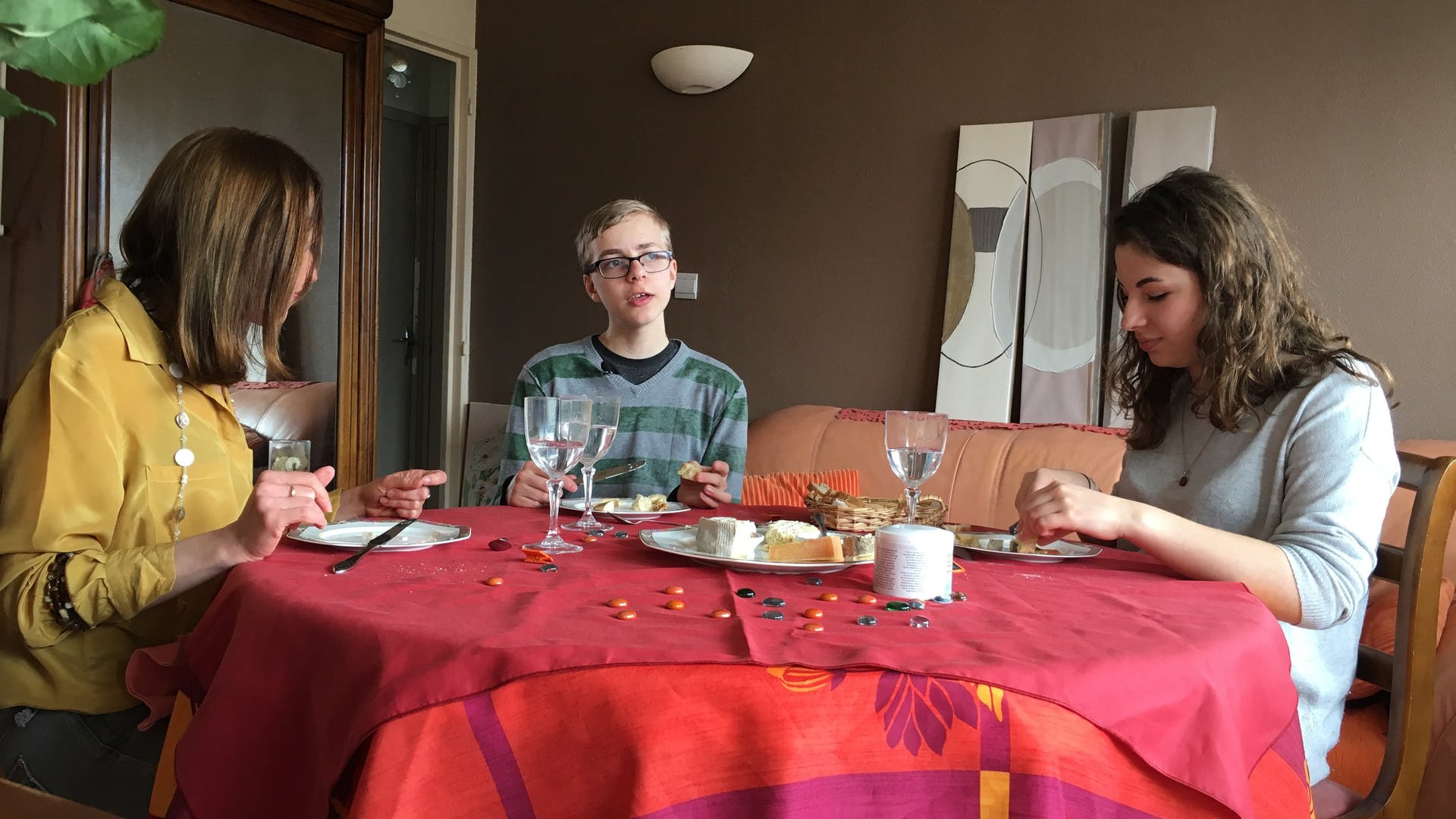 Drei junge Menschen sitzen an einem Tisch.