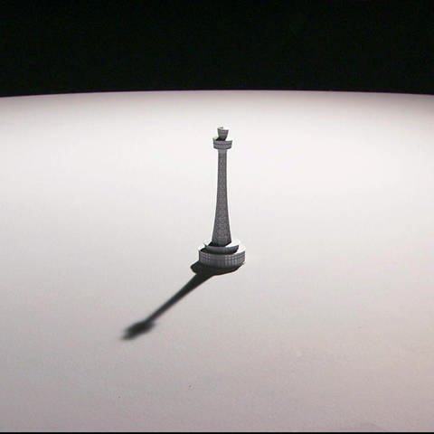 Eine kleine Figur wirft einen Schatten auf einen Tisch. (Foto: SWR - Screenshot aus der Sendung)