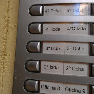 Ein Klingelschild auf dem nur Zahlen und spanische Abkürzungen für Etagen stehen.