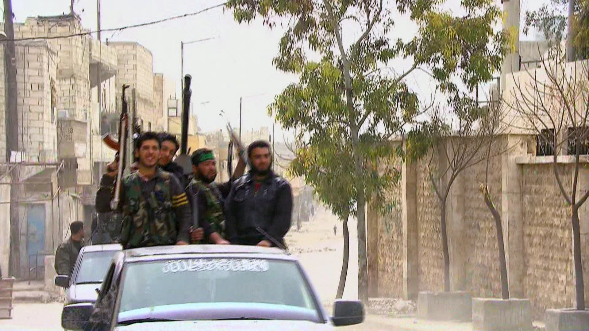 Bewaffnete Kämpfer einer syrischen Miliz auf der Ladefläche eines Pick-Ups.