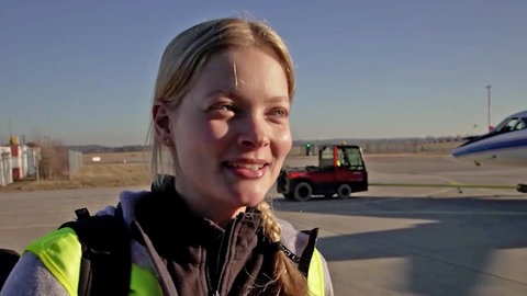 Eine junge Frau lächelt während eines Interviews in die Kamera.