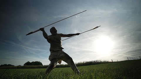 Experimentalarchäologe Rudi Walter schleudert einen Holzspeer mit einer Speerschleuder
