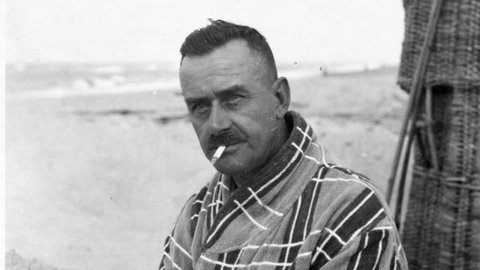 Schwarzweiß-Bild: Thomas Mann im Bademantel mit Zigarette im Mundwinkel