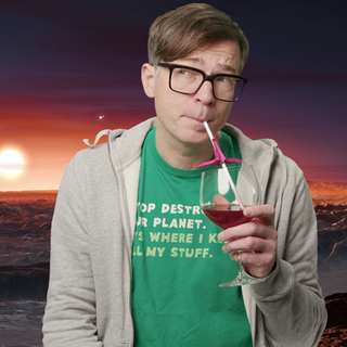 Ralph Capars steht nachdenklich vor einer mondartigen Landschaft mit Sonnenuntergang