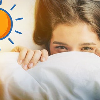 Es ist hell: Mädchen schaut unter der Bettdecke hervor. Was macht Sonnenlicht mit unserem Körper?
