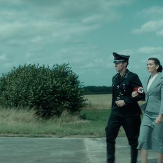 Spielszene: Wernher von Braun in SS-Uniform hat seine Sekretärin untergehakt. Der Ingenieur baut im Zweiten Weltkrieg Raketen für Hitler.