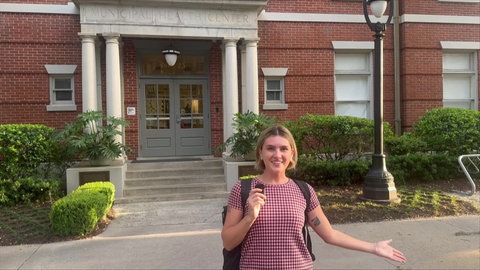 Lily vor einem historischen Gebäude ihrer Universität.